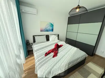 a red teddy bear sitting on a bed in a bedroom at Marrakech Central 2BDR w Huge Terrace near Serdika in Sofia