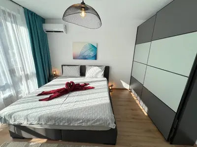 a bedroom with a bed with a red ribbon on it at Marrakech Central 2BDR w Huge Terrace near Serdika in Sofia