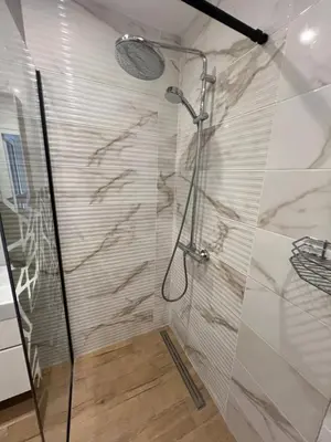 a bathroom with a shower with a glass door at Marrakech Central 2BDR w Huge Terrace near Serdika in Sofia