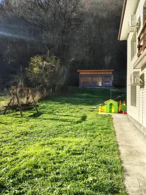 a yard with a house and a play set at Вила Владислава - стаи за гости in Cherni Vit