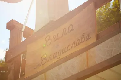 a wooden sign on a building with the words toledo blvd excellence at Вила Владислава - стаи за гости in Cherni Vit