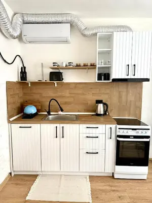 a kitchen with white cabinets and a sink at Atelier-apartament in Sandanski