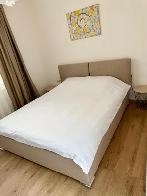 a bed in a bedroom with a white mattress at Atelier-apartament in Sandanski