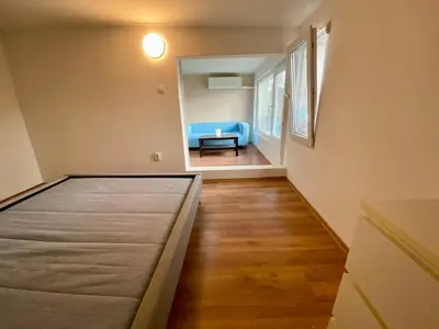 a bedroom with a bed and a blue couch at Small Bijou on the rooftop in Sofia
