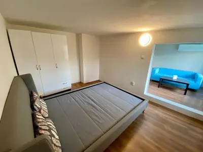 a bedroom with a bed and a blue couch at Small Bijou on the rooftop in Sofia