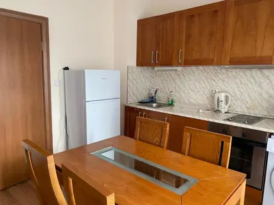 a kitchen with a wooden table and a white refrigerator at Cedar Lodge Apartament - Gondola in Bansko