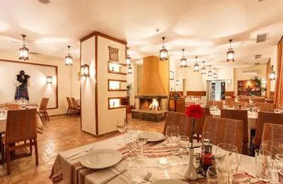 a dining room with tables and chairs and a fireplace at Forestside Stay at Stream Resort in Stoykite