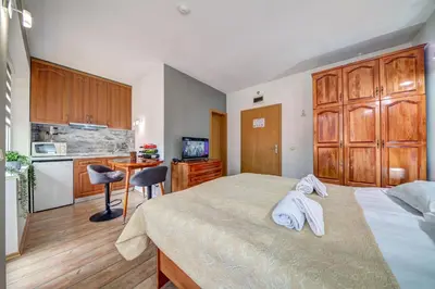 a bedroom with a large bed and a kitchen at Forestside Stay at Stream Resort in Stoykite