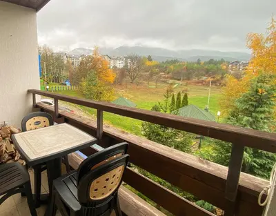 a balcony with a table and chairs and a view at Green Life Private Apartment D27 in Bansko