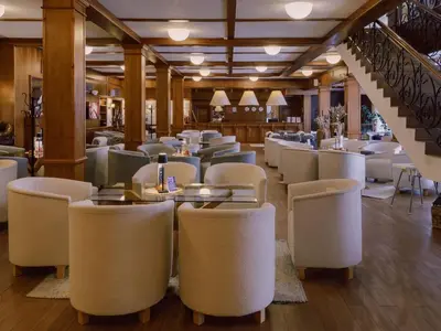 a restaurant with white chairs and tables and a staircase at Green Life Private Apartment D27 in Bansko