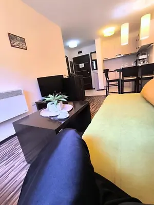 a living room with a large bed and a table at Warm Evenings and free Bottle of Wine in Perun Lodge in Bansko