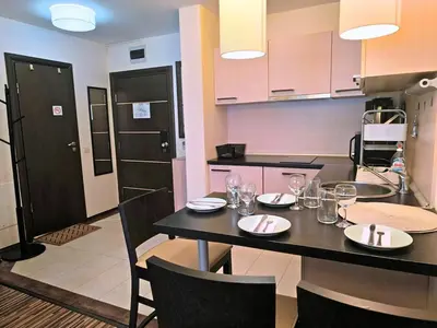 a kitchen with a table with plates and glasses on it at Warm Evenings and free Bottle of Wine in Perun Lodge in Bansko