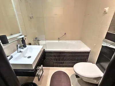 a bathroom with a tub and a toilet and a sink at Warm Evenings and free Bottle of Wine in Perun Lodge in Bansko