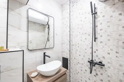 a bathroom with a sink and a mirror at Panoramic View Cozy 1BR Apartment in Plovdiv