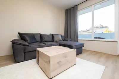 a living room with a couch and a large window at Panoramic View Cozy 1BR Apartment in Plovdiv