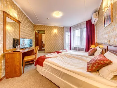 a hotel room with a large bed and a desk at Хотел Елит Релакс in Devin