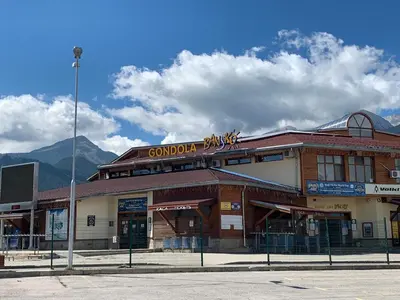 a building with a sign on top of it at Bansko 3 Ski To Door Apartment in Bansko
