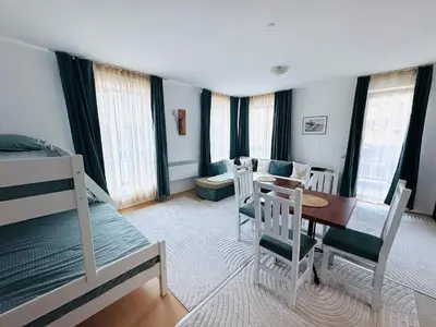 a room with a table and chairs and a bedroom at Bansko 3 Ski To Door Apartment in Bansko