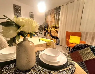 a table with plates and a vase with flowers on it at Superior studio with terrace in 4star Green Life Bansko in Bansko