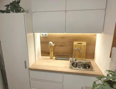 a kitchen with a sink in a wooden cabinet at Superior studio with terrace in 4star Green Life Bansko in Bansko