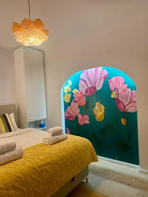 a bedroom with a mural of flowers on the wall at Apartment Juliet in Sofia