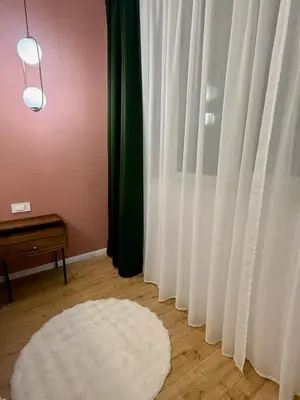 a white rug on the floor next to a window at Apartment Juliet in Sofia