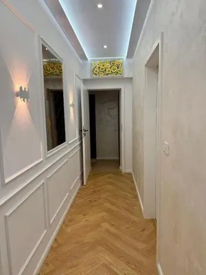 a hallway with white walls and wood floors and a ceiling at Apartment Juliet in Sofia