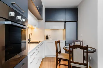 a kitchen with white cabinets and a table and chairs at Modern Stay with Balcony in Sofia