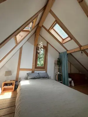 a bedroom with a large bed in a attic at Cozy frame house in the wood