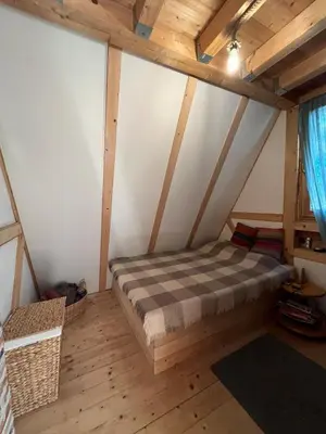 a bedroom with a bed in a attic at Cozy frame house in the wood