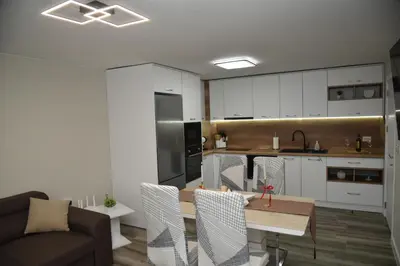 a kitchen and living room with a table and chairs at C&A Apartment in Gotse Delchev