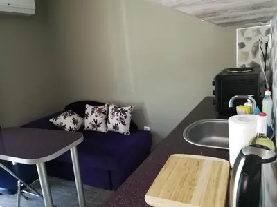 a small kitchen with a blue couch and a sink at Studio 11 Plovdiv in Plovdiv