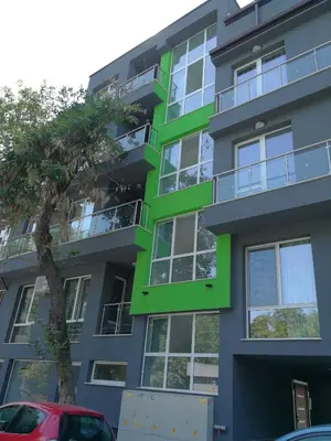a green building with a tree in front of it at Studio 11 Plovdiv in Plovdiv