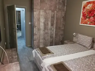 a bedroom with a bed with a wooden wall at Studio 11 Plovdiv in Plovdiv