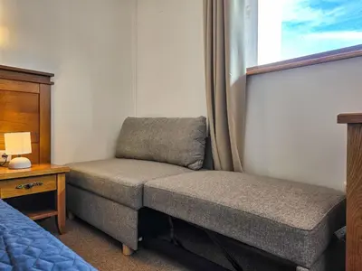 a bedroom with a couch and a bed and a window at EDEL View! 1BR Ap with Top Mountain View in Bansko in Bansko