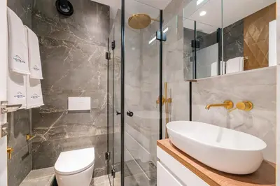 a bathroom with a toilet and a sink and a shower at NOVITA Hotel Sofia FREE UNDERGROUND PARKING in Sofia