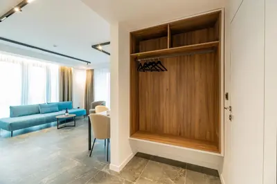 a living room with a blue couch and a wooden door at NOVITA Hotel Sofia FREE UNDERGROUND PARKING in Sofia