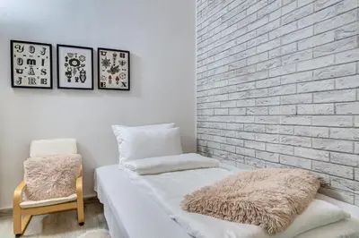 a bedroom with a brick wall and a bed and a chair at Sweet Home Family Lodge at Grand Monastery in Smolyan