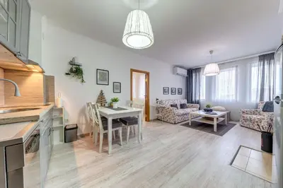 a kitchen and living room with a table and chairs at Sweet Home Family Lodge at Grand Monastery in Smolyan
