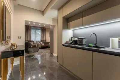 a kitchen with a counter and a living room at Exclusive Luxury Central Apartment in Sofia