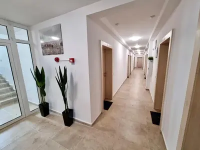 a corridor of an office with white walls and plants at Flex loft in Sofia