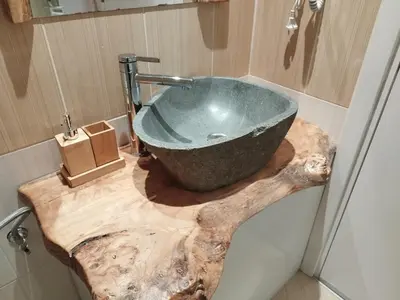 a bathroom with a stone sink on a wooden counter at Alpin Art Studio in Hotel Iceberg - Free Pool, Sauna and Fitness in Borovets