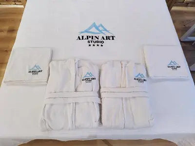 a group of white mittens and socks on a bed at Alpin Art Studio in Hotel Iceberg - Free Pool, Sauna and Fitness in Borovets
