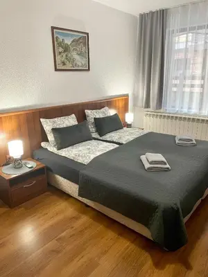 a bedroom with a large bed and two lamps at The Cozy Spot by the Ski Lift Gondola by SI Stay in Bansko