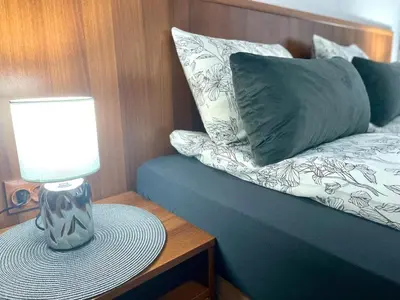 a lamp on a table next to a bed with a pillow at The Cozy Spot by the Ski Lift Gondola by SI Stay in Bansko
