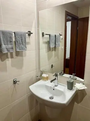 a white bathroom with a sink and a mirror at The Cozy Spot by the Ski Lift Gondola by SI Stay in Bansko