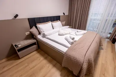 a bedroom with a bed with white towels on it at City Home Sandanski in Sandanski
