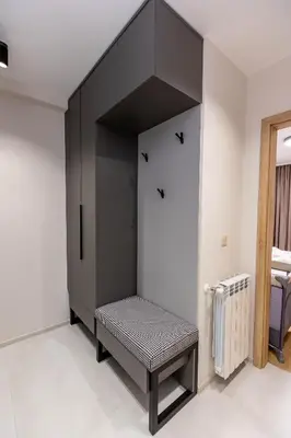a black cabinet with a bench in a room at City Home Sandanski in Sandanski