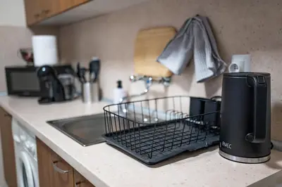a kitchen counter with a dish drying rack on a sink at NDK Garden at Vitosha Blvd Absolutely Top Center with Free Parking in Sofia