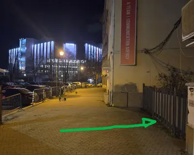 a green arrow on the side of a building at night at NDK Garden at Vitosha Blvd Absolutely Top Center with Free Parking in Sofia